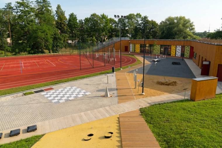 Areál Komunitního centra Všichni spolu se sportovním hřištěm, herními prvky a šachovnicí